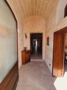 un corridoio di un edificio con pavimento piastrellato e porta di Buen Retiro - Casa Vacanze a Depressa