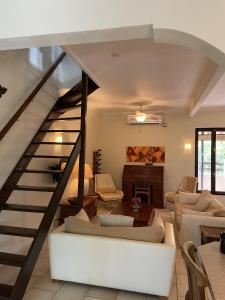 uma sala de estar com uma escadaria com mobiliário branco em Cunucu Jucasa em Noord
