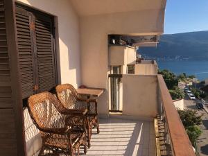 two wicker chairs sitting on the balcony of a building at Korra in Herceg-Novi