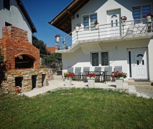 a house with a table and chairs in front of it at Apartman Pogled Arilje in Arilje