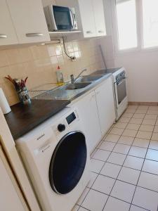 una cucina con lavatrice e lavandino di Superbe appart 2 pièces -accès autonome- avec parking gratuit a Chaville