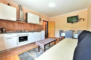 a kitchen with white cabinets and a living room at Biljevina in Saborsko +37 photos