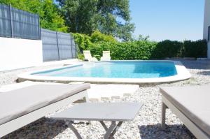 una piscina con 2 sillas y una mesa en Le Grand Cèdre - 2 Chambres d'hôtes - Sud Ardèche en Bourg-Saint-Andéol
