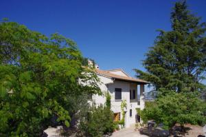 una casa blanca con árboles delante de ella en Le Grand Cèdre - 2 Chambres d'hôtes - Sud Ardèche en Bourg-Saint-Andéol