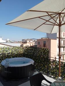 una vasca idromassaggio sotto un ombrellone su un tetto di Mary Gery's Rooms a Castellammare del Golfo