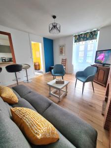 - un salon avec un canapé, des chaises et une télévision dans l'établissement Gîte la Libellule 4 couchages 15 min du Puy du Fou, à Saint-Amand-sur-Sèvre