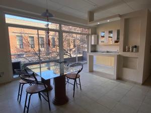 a kitchen and dining room with a glass table and chairs at DUPLEX A PASOS DE PLAZA URQUIZA in San Miguel de Tucumán