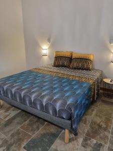 a bed with a blue comforter and pillows in a room at Villa MALOEM in Sainte-Anne