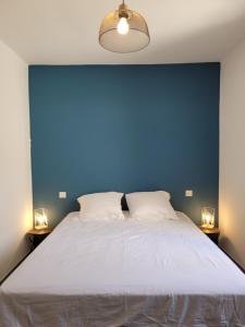 a bedroom with a large bed with a blue wall at L'Oustau de Laëtitia Animaux bienvenus in Fontaine-de-Vaucluse