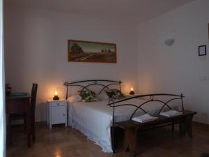 MorleschioAgriturismo Pozzo dei Cocci的一间卧室配有一张床、一张桌子和两盏灯。