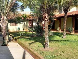 a group of palm trees in front of a house at Conforto com aconchego e paz in Ilha Comprida