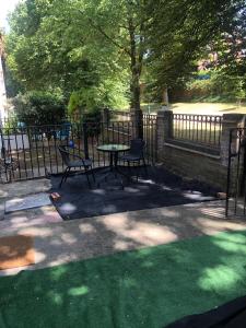 une terrasse avec une table et des chaises à côté d'une clôture dans l'établissement Waterloo House, à Nottingham
