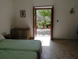 1 dormitorio con 1 cama y puerta a un patio en Villa Filomena, en Montecorice
