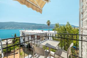 balcón con mesa, sillas y vistas al océano en Boka Apartment 6 en Herceg-Novi