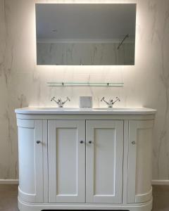 a bathroom with a white sink and a mirror at Holyland House - Greenacres Estates in Pembrokeshire