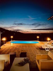 a swimming pool at night with lights on at Lexor Holiday Home in Tuzla