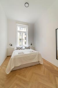 a white bedroom with a large bed and a window at Ferdinand I levestate in Vienna