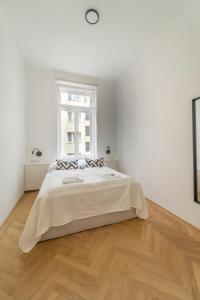 biała sypialnia z dużym łóżkiem i oknem w obiekcie josef's home I Deluxe Apartment in Ideal Location w Wiedniu