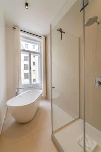 W łazience znajduje się wanna i przeszklony prysznic. w obiekcie josef's home I Deluxe Apartment in Ideal Location w Wiedniu +27 zdjęć