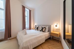 sypialnia z białym łóżkiem i 2 oknami w obiekcie josef's home I Deluxe Apartment in Ideal Location w Wiedniu