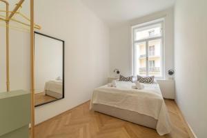 sypialnia z łóżkiem i lustrem w obiekcie josef's home I Deluxe Apartment in Ideal Location w Wiedniu