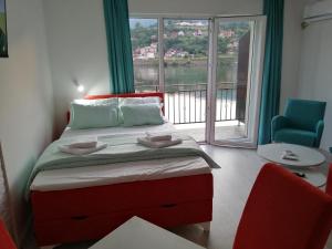 um quarto com uma cama e uma grande janela em Vila Leolaz em Višegrad