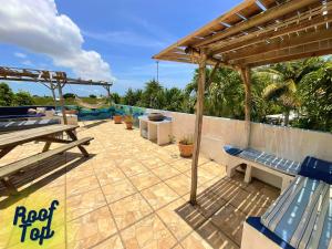 a patio with two blue chairs and a picnic table at Caraiba Villa & Bungalows in Sainte-Anne