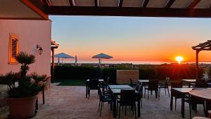 a patio with tables and chairs and a sunset at Il giardino dei tramonti in Nardò