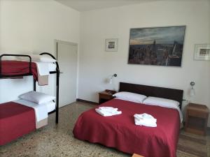 1 dormitorio con 2 camas y una manta roja con toallas en Affittacamere Mark, en Faenza