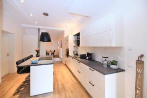Una cocina con gabinetes blancos y encimera. en Das schiefe Haus - Wohnung "Altstadt", en Heppenheim an der Bergstrasse