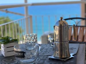a table with a blender and two glasses on it at Don Pedro Beach House in Savona
