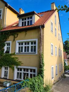 uma casa amarela com um telhado vermelho em Apartament w Starej Szkole em Srebrna Góra