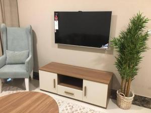 a living room with a flat screen tv on a wall at Lovely Beach Apartment in Salalah