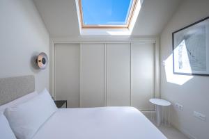 um quarto com uma cama branca e uma janela em Málaga Centro Terraza 4-D em Málaga