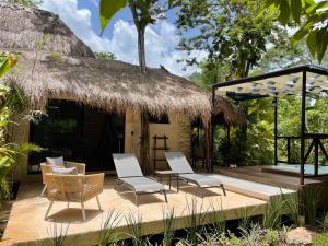 a resort with chairs and a thatch roof at Aldea Coba An Escape Boutique Experience in Cobá