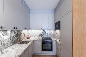 una cocina blanca con armarios blancos y fregadero en Apartament Let's Sea A17 Gąski, en Gąski
