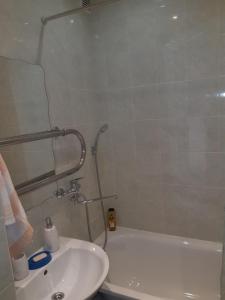 ein Bad mit einer Badewanne, einem Waschbecken und einer Dusche in der Unterkunft Saules 116 in Ventspils