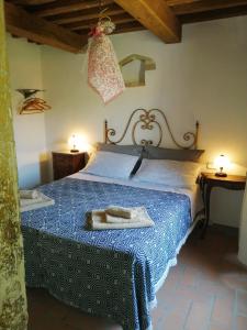 1 dormitorio con 1 cama grande y colcha azul en LA BOTTEGA DEL CALZOLAIO, en Castiglion Fibocchi