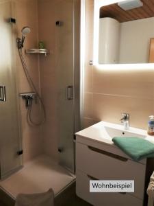 La salle de bains est pourvue d'une douche et d'un lavabo. dans l'établissement Taubennest, à Waabs