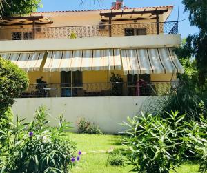 a house with a balcony in front of it at Afrodite Hotel Apartments in Myrina