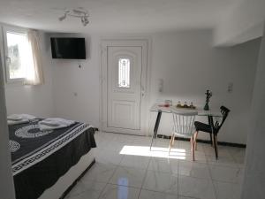 a bedroom with a bed and a table and a door at Countryside Retreat 3 in Agios Arsenios
