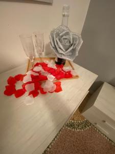 a table with two wine glasses and red flowers on it at HOME ADRIANA in Bari