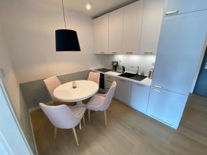 eine Küche mit einem Tisch und Stühlen im Zimmer in der Unterkunft Polanki Aqua Apartament LUNA in Kołobrzeg
