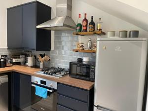 a kitchen with a stove top oven next to a refrigerator at Renovated apartment, Galashiels A7 in Galashiels