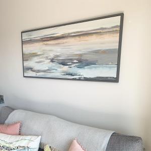 a painting hanging on a wall above a couch at Sea View Terrace in Newcastle