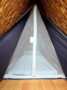 ein blau-weißes Zelt auf einem Holzboden in der Unterkunft Calatagan's Bahay Kubo - with Beach Access in Batangas City
