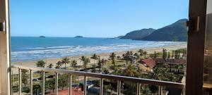 a view of the beach from the balcony of a resort at APARTAMENTO EM FRENTE A PRAIA in Peruíbe
