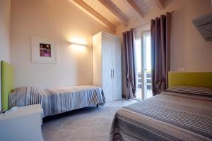 カポリーヴェリにあるCamping Village Le Calanchioleのベッド2台と窓が備わるホテルルームです。