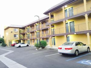 dos autos estacionados en un estacionamiento frente a un edificio en Simply Home Inn & Suites - Riverside, en Riverside