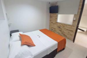 Dormitorio con cama con almohada naranja en Hotel San Lorenzo, en Bucaramanga